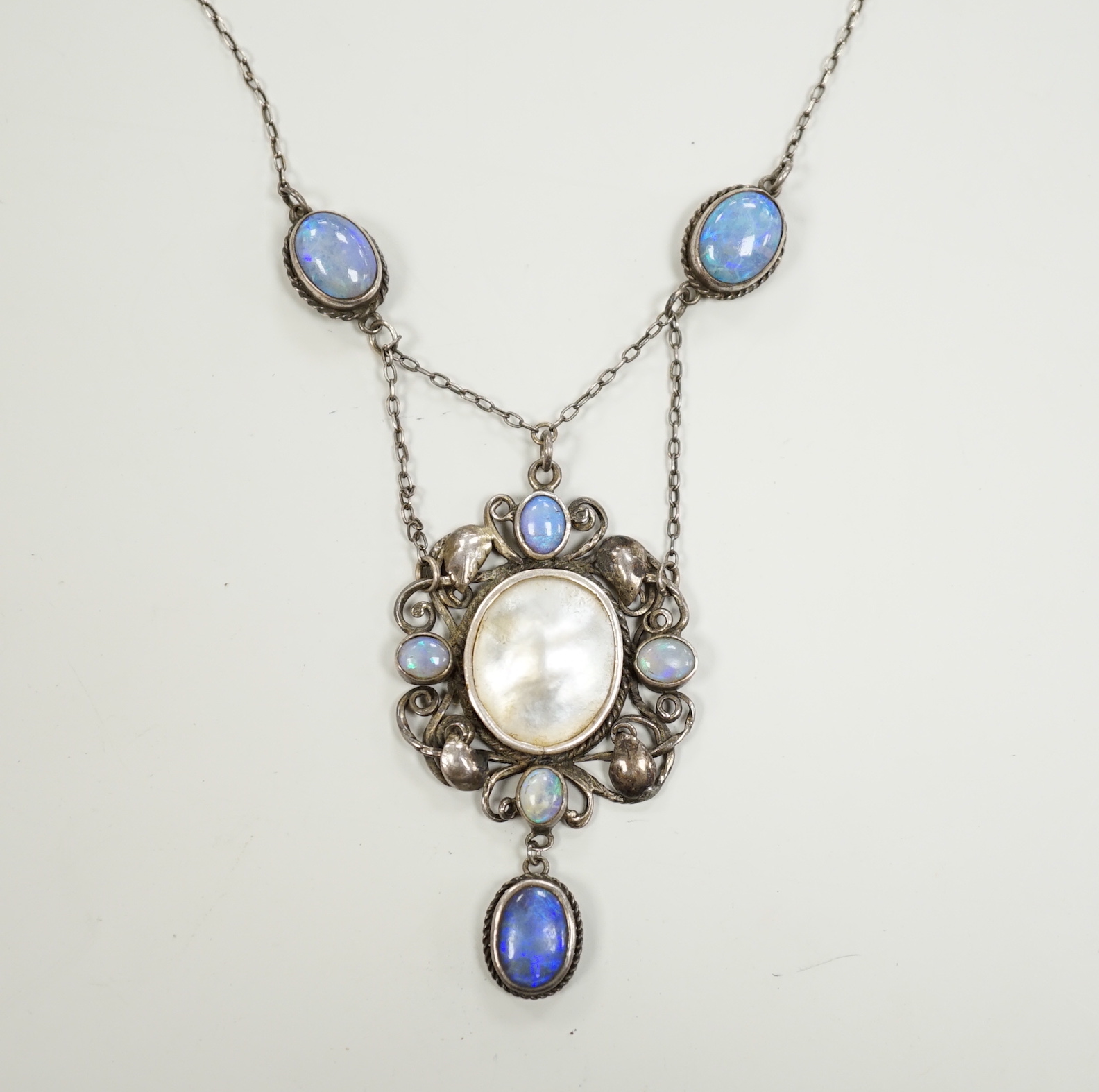 An Arts & Crafts white metal, mother of pearl and gem set drop pendant necklace, in the manner of Sybil Dunlop, overall 56cm.